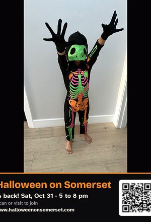 A kid in a glow skeleton costume, with event details & QR code